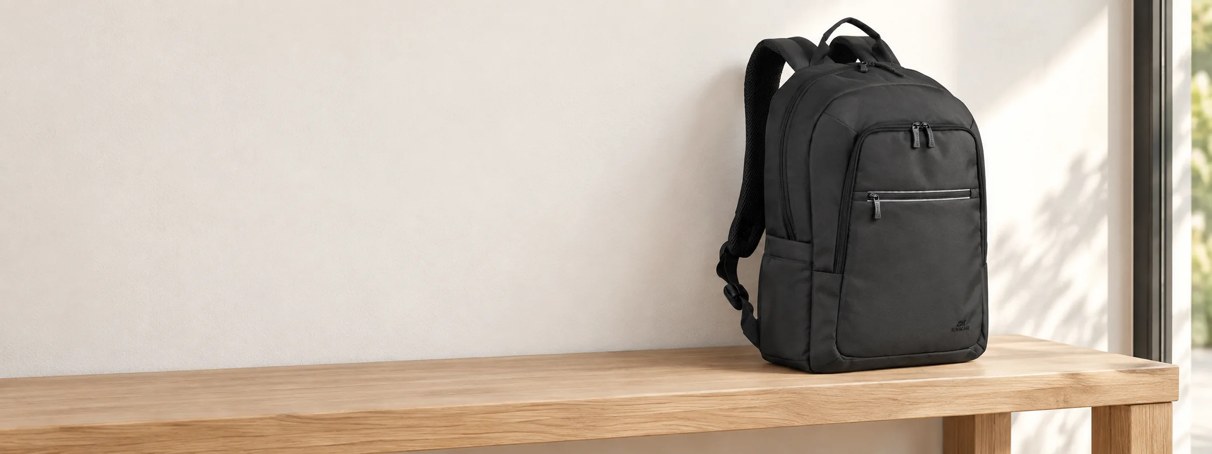 Sac à dos, sacoche et housse RIVACASE posés dans un intérieur clair